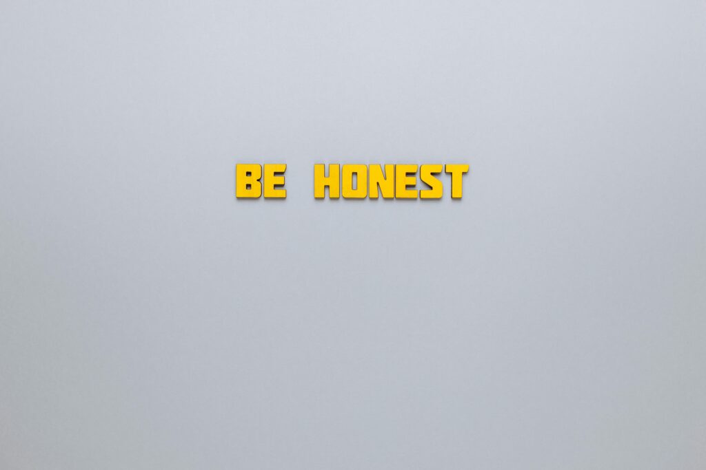 Simple yellow text 'Be Honest' on a neutral background, emphasizing clarity and inspiration.